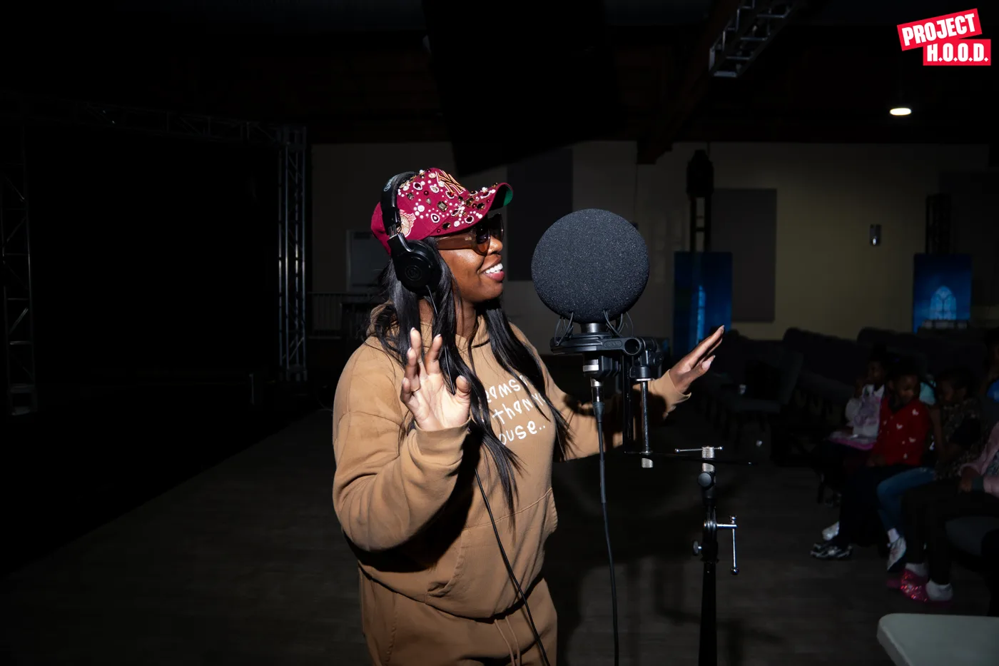 Ta'Rhonda Jones on a microphone in front of her class at Project H.O.O.D.